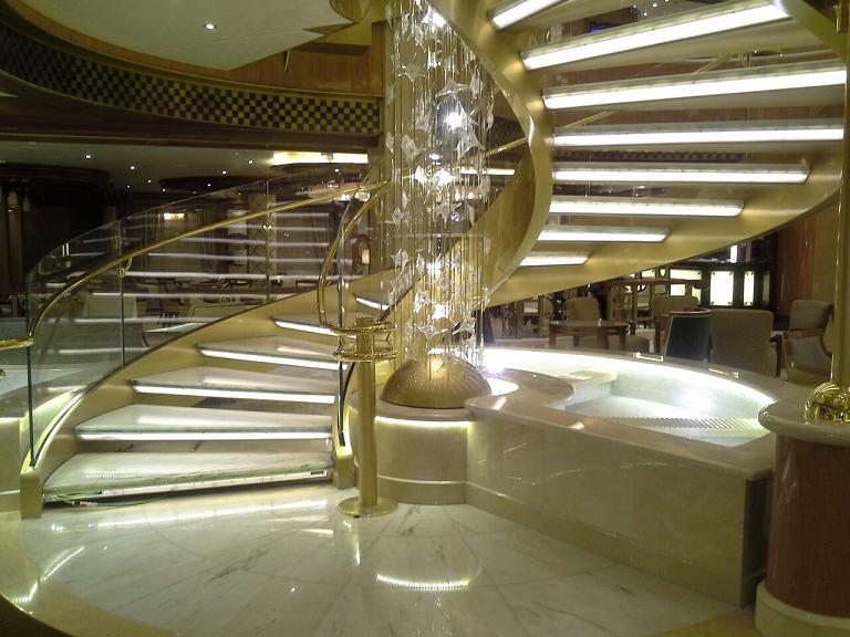 Royal Princess Atrium Fountain. Covering of solid curved pieces crema marfil marble