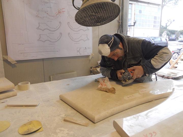 Skilled worker, working manually on a solid piece curve of marble